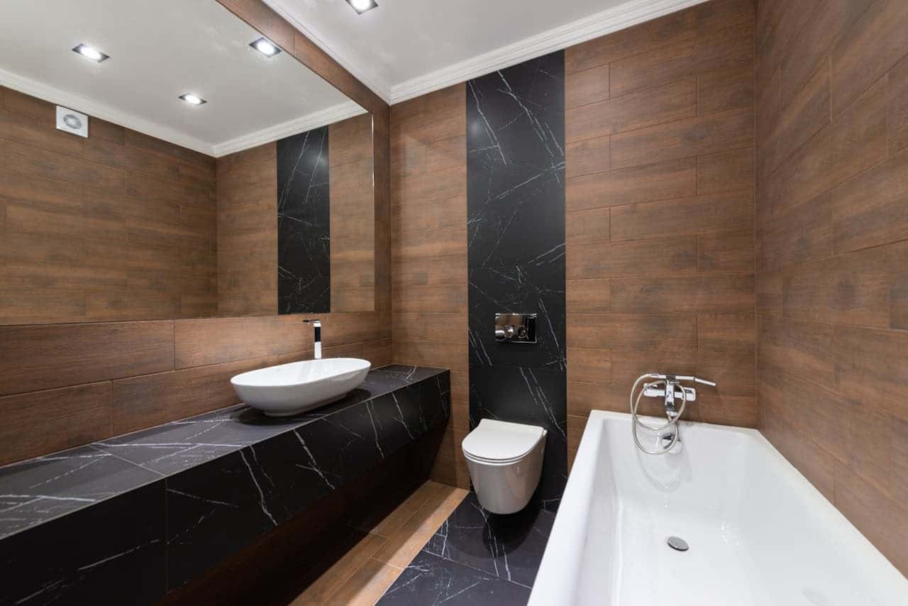 Refined bathroom with warm stone surfaces and frameless glass