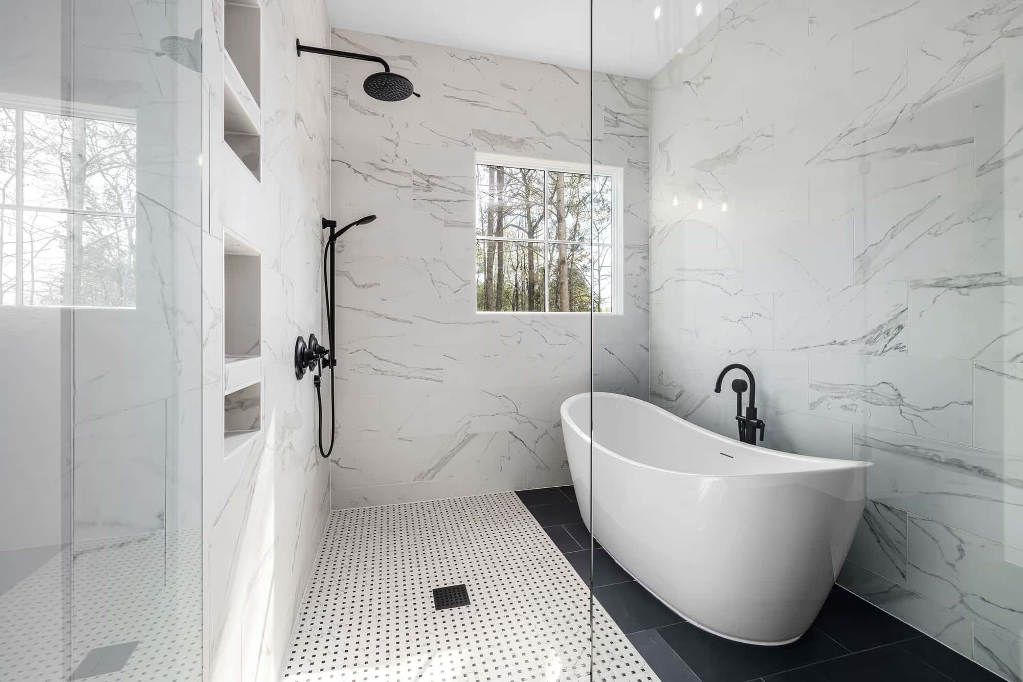Bright marble bathroom with freestanding bath, walk-in shower and matte black fittings