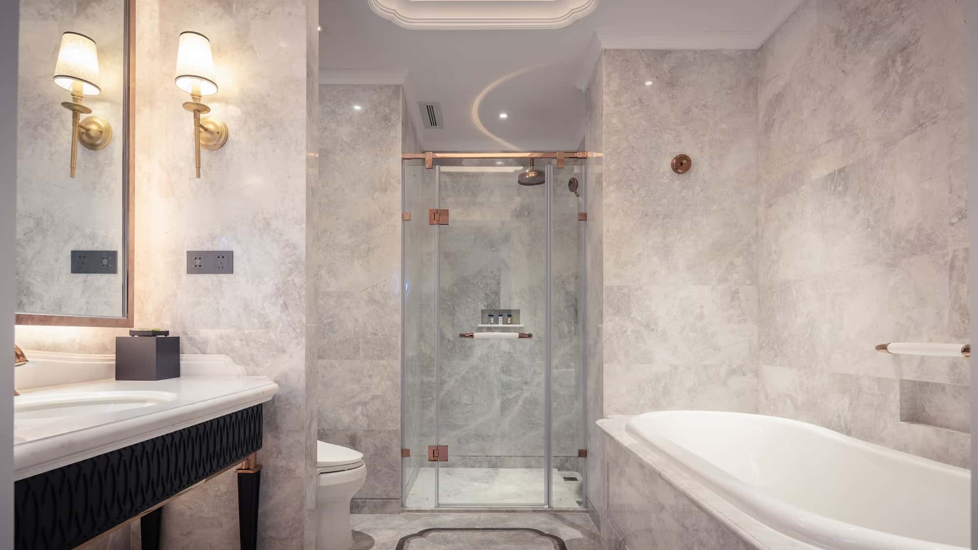 Classic bright bathroom with marble walls, wall sconces and walk-in shower