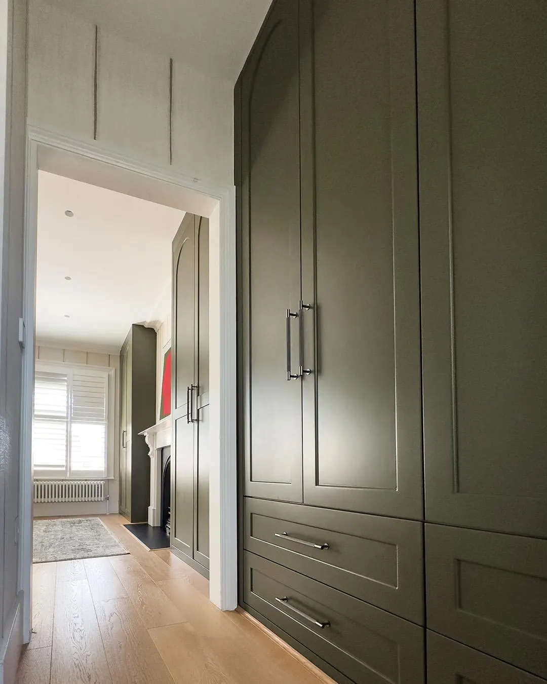 Alcove wardrobe with drawers below and arched panel doors