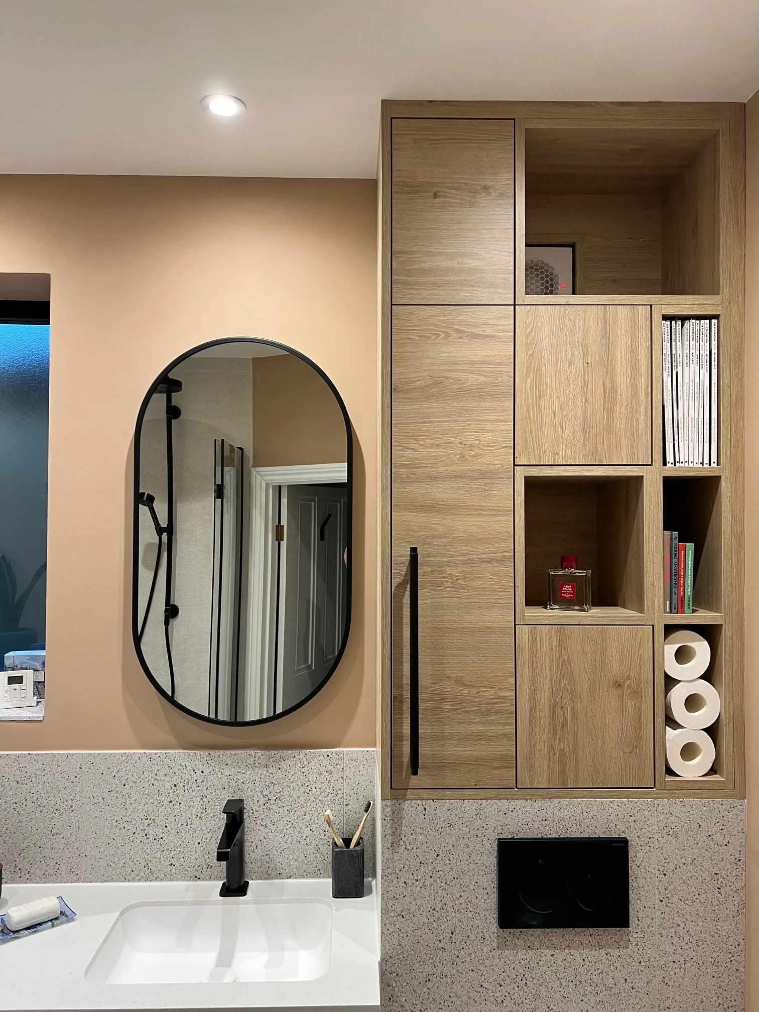 Our completed Northfields bathroom with fitted storage and black fittings
